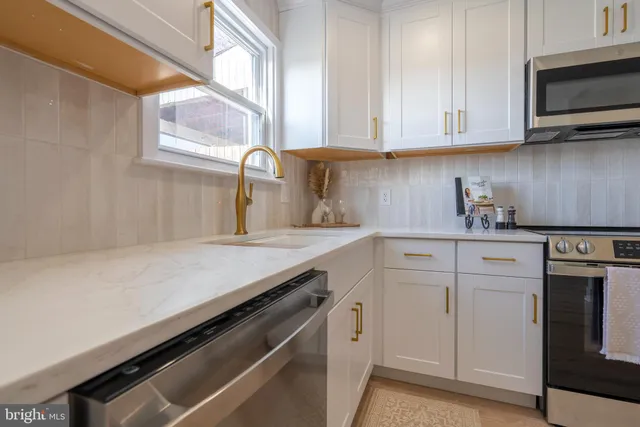 a kitchen with white cabinets and a sink