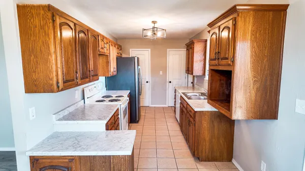 a kitchen with stainless steel appliances granite countertop a sink dishwasher stove and refrigerator with wooden floor