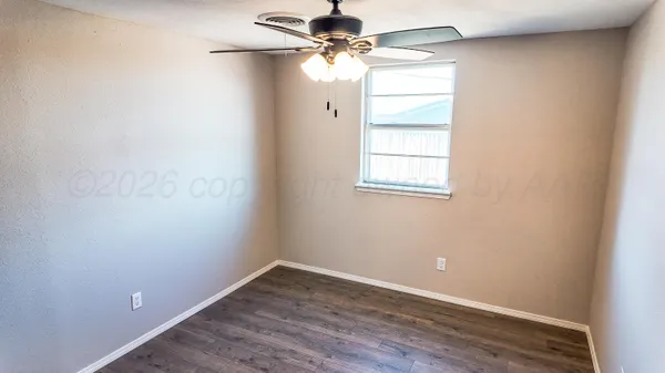 an empty room with a window and a ceiling fan