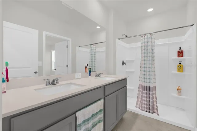 a bathroom with a sink double vanity and a shower