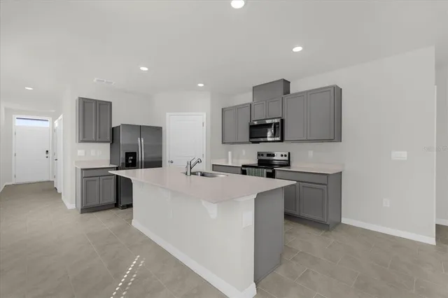 a large kitchen with cabinets stainless steel appliances and a counter top space