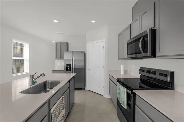 a kitchen that has a sink and a stove top oven