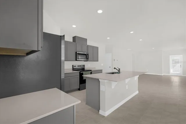a kitchen with a sink a stove top oven and white stainless steel appliances