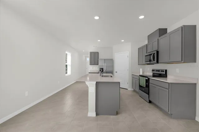 a kitchen with stainless steel appliances granite countertop a refrigerator sink and stove