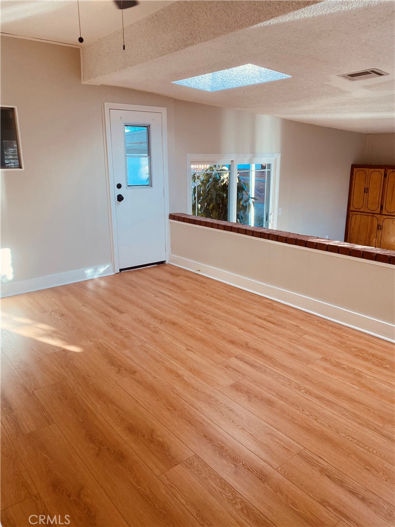 11745 Bryant Street Yucaipa, CA 92399 - Photo 15 of 28 an empty room with wooden floor and windows