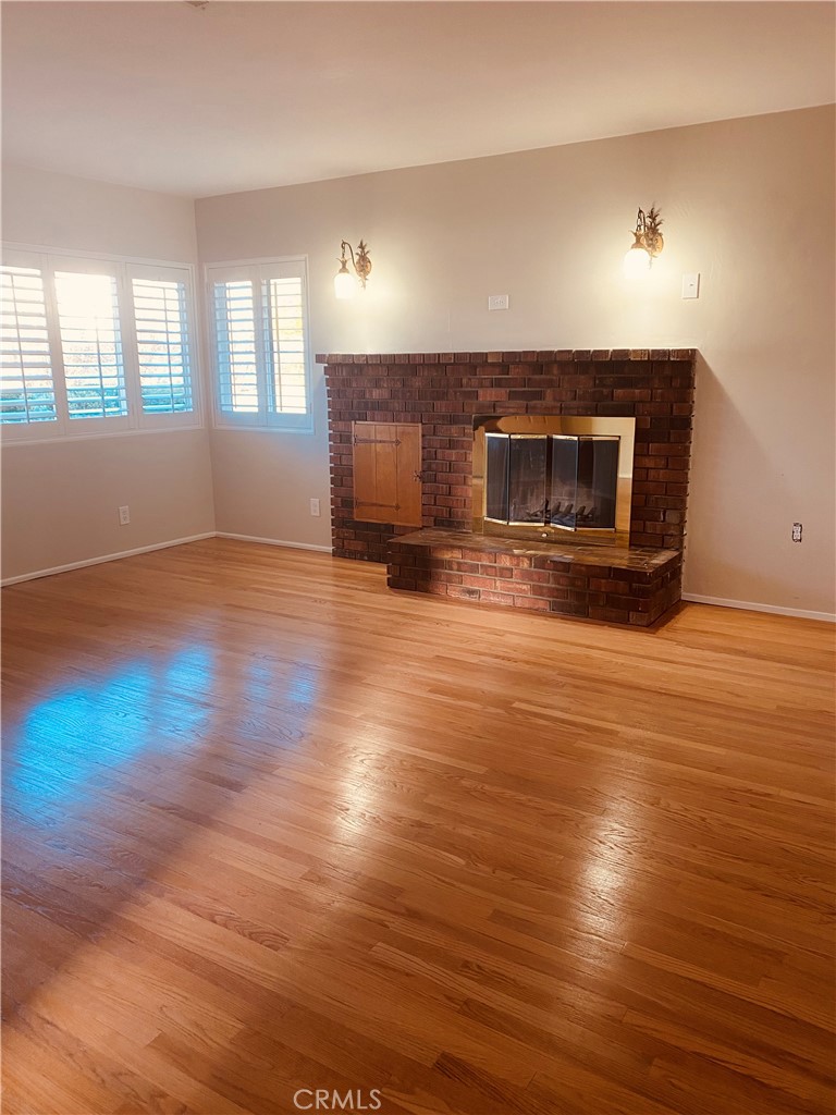 11745 Bryant Street Yucaipa, CA 92399 - Photo 4 of 28 a view of empty room with wooden floor and fireplace