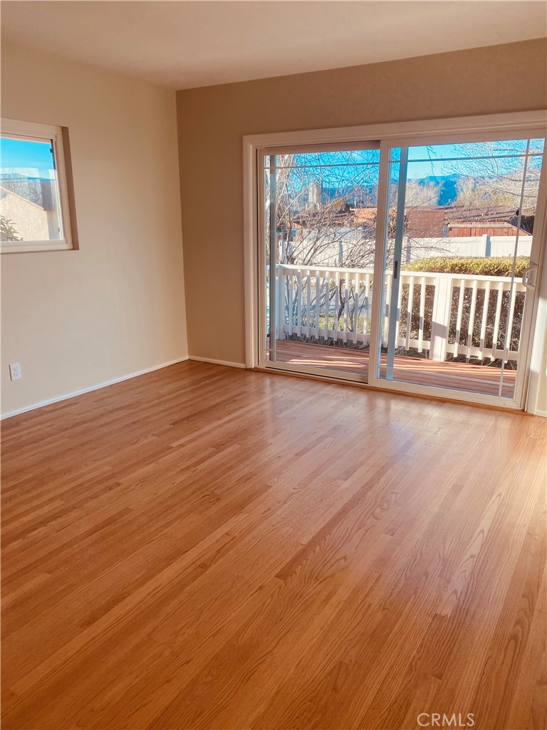 11745 Bryant Street Yucaipa, CA 92399 - Photo 7 of 28 an empty room with wooden floor and a floor to ceiling window