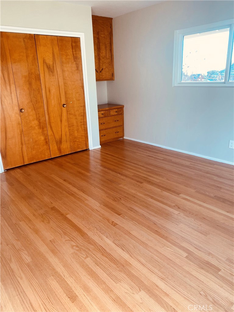 11745 Bryant Street Yucaipa, CA 92399 - Photo 8 of 28 a view of an empty room with wooden floor and a window