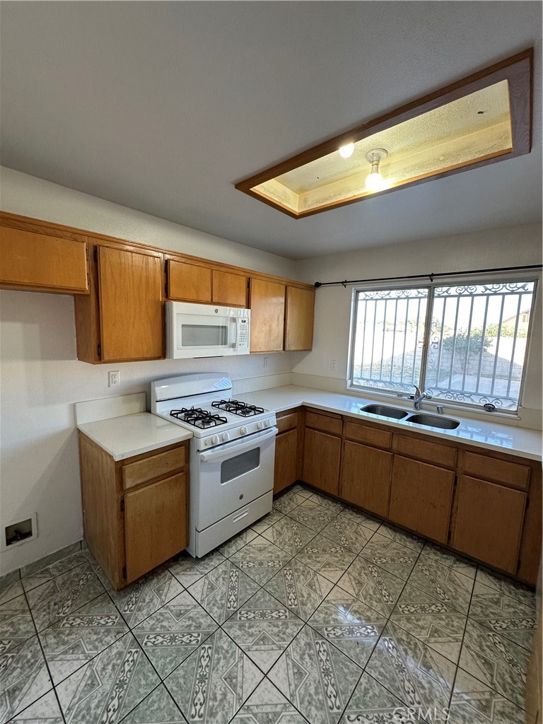 8505 Robinia Street Fontana, CA 92335 - Photo 13 of 30 a kitchen with stainless steel appliances granite countertop a stove a sink and a refrigerator