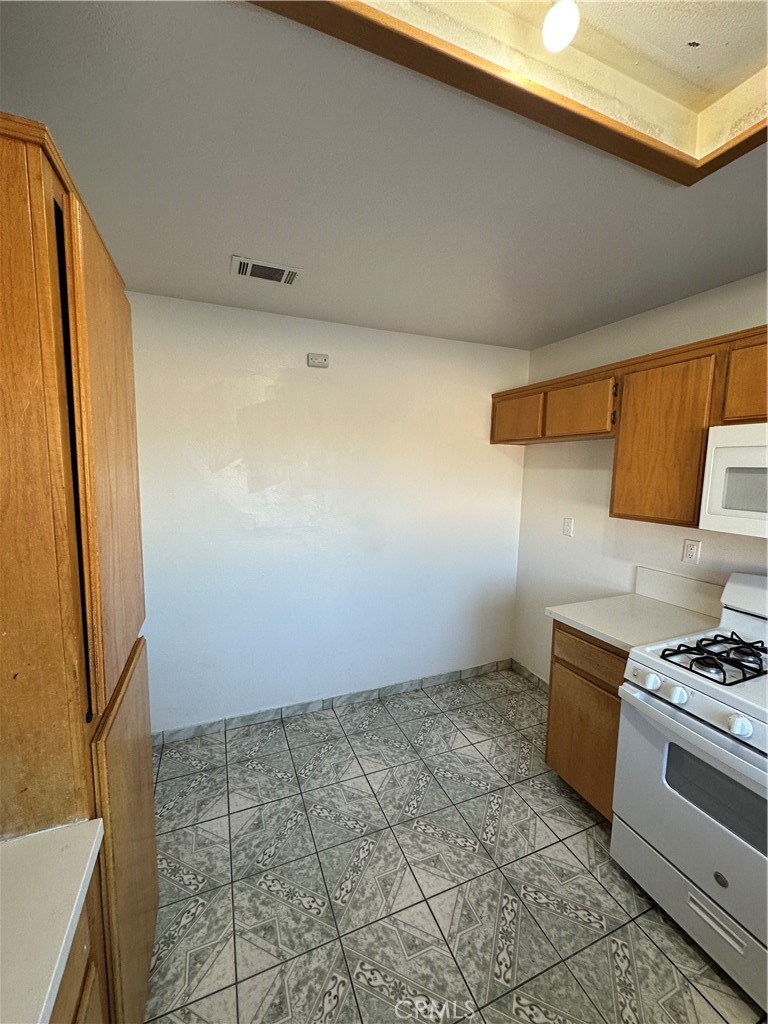 8505 Robinia Street Fontana, CA 92335 - Photo 15 of 30 a kitchen with a stove a refrigerator and cabinets