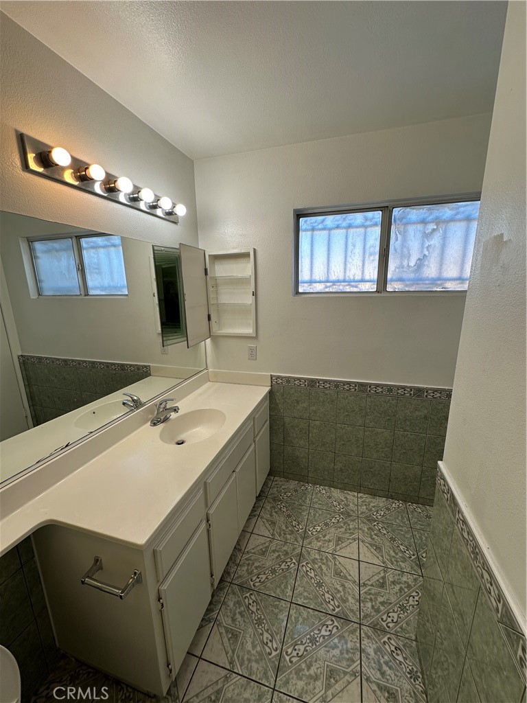 8505 Robinia Street Fontana, CA 92335 - Photo 6 of 30 a bathroom with a sink a toilet and a mirror