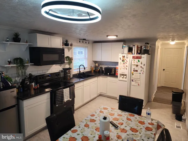 a kitchen with stainless steel appliances a refrigerator and a stove top oven
