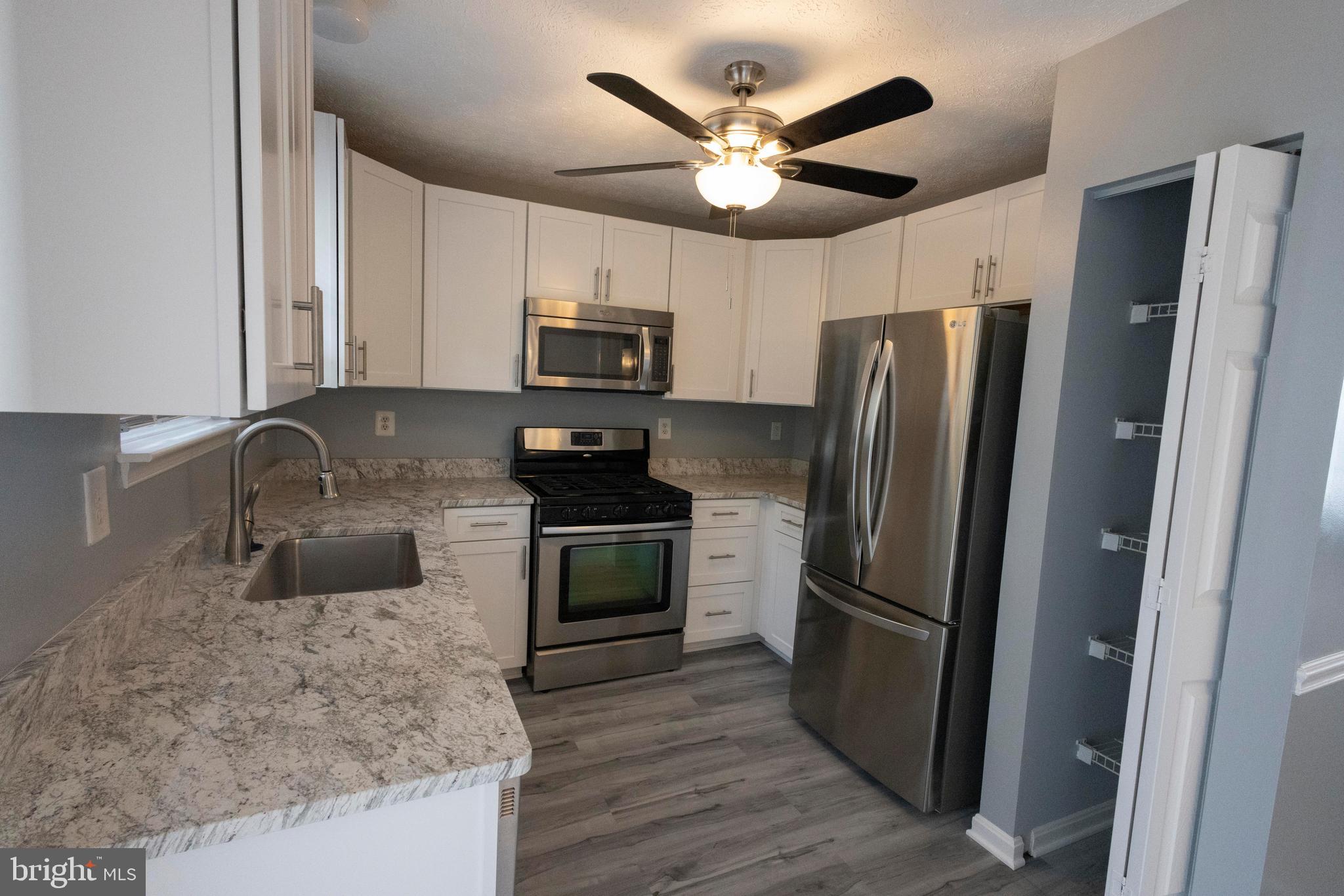 502 Buckstone Garth Abingdon, MD 21009 - Photo 32 of 36 a kitchen with stainless steel appliances granite countertop a refrigerator a stove a sink and a microwave