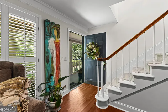 a kitchen with a table chairs refrigerator and wooden floor
