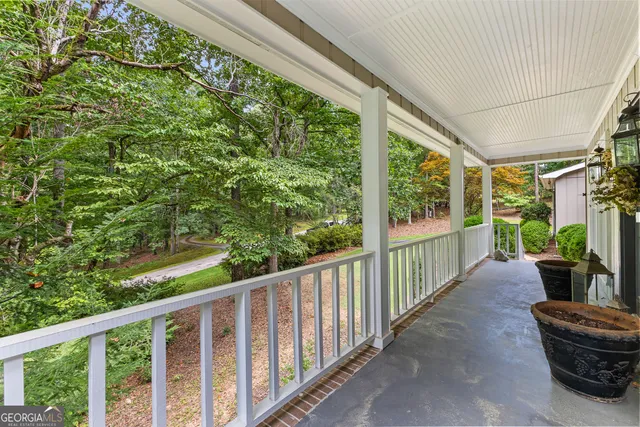 a view of a dining room with furniture a chandelier and large windows
