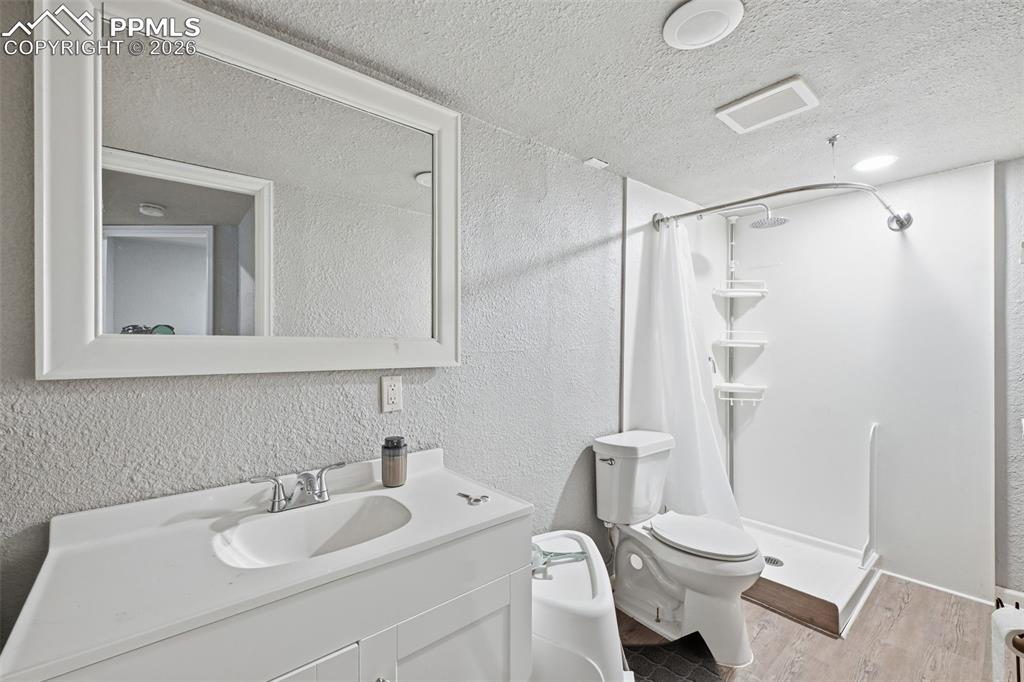 6186 Pilgrimage Road Colorado Springs, CO 80925 - Photo 14 of 20 a bathroom with a sink vanity mirror and toilet