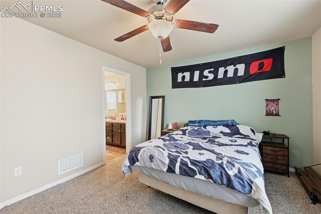 6186 Pilgrimage Road Colorado Springs, CO 80925 - Photo 16 of 20 a bedroom with a bed and a chandelier