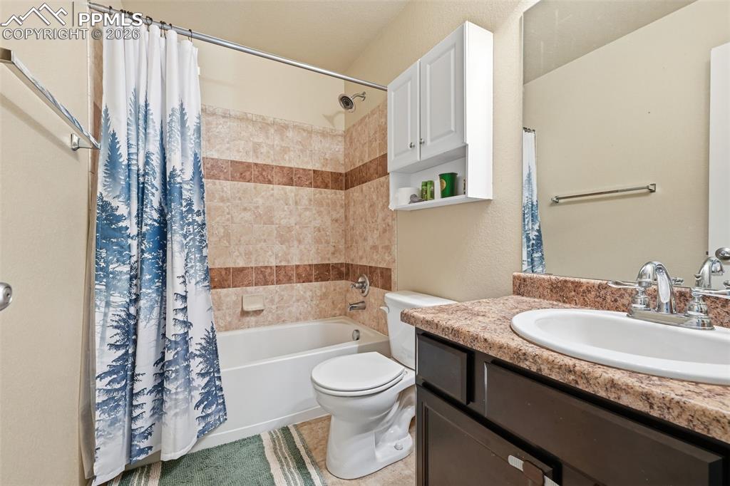 6186 Pilgrimage Road Colorado Springs, CO 80925 - Photo 18 of 20 a bathroom with a granite countertop sink toilet and shower