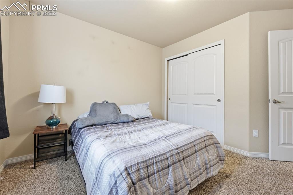 6186 Pilgrimage Road Colorado Springs, CO 80925 - Photo 20 of 20 a bedroom with a bed and a lamp