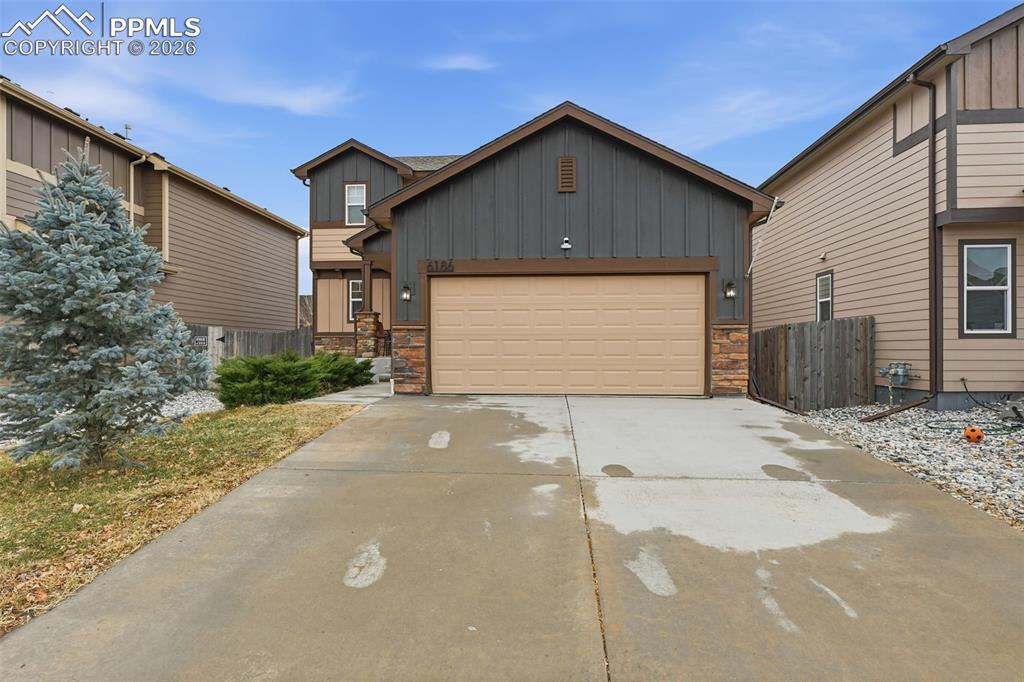 6186 Pilgrimage Road Colorado Springs, CO 80925 - Photo 2 of 20 a front view of a house with a yard and garage
