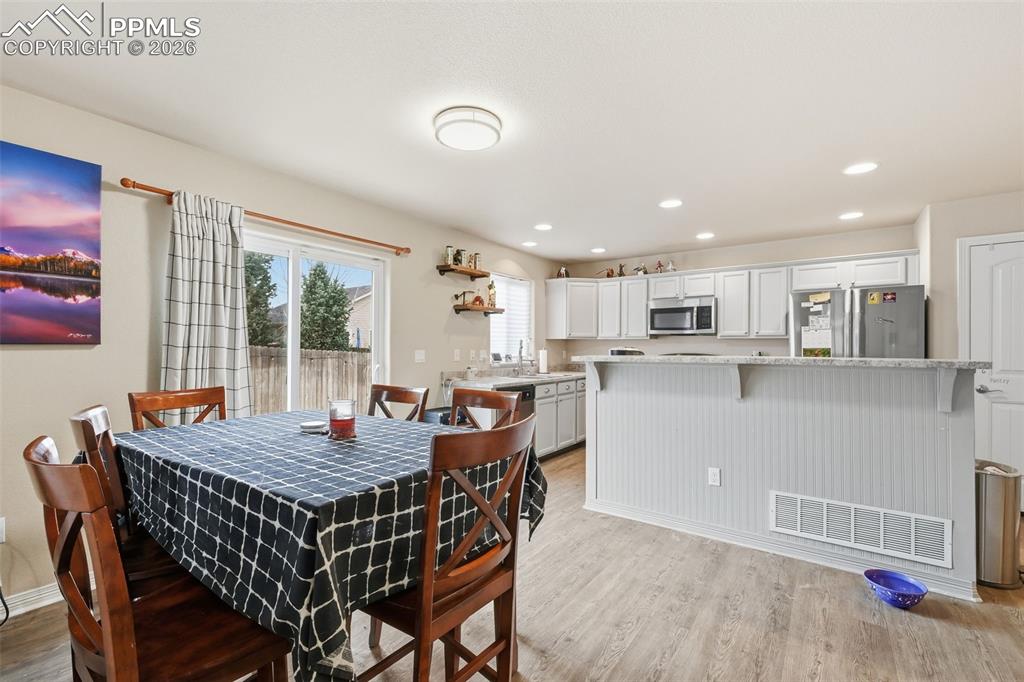 6186 Pilgrimage Road Colorado Springs, CO 80925 - Photo 5 of 20 a view of a dining room with furniture and wooden floor