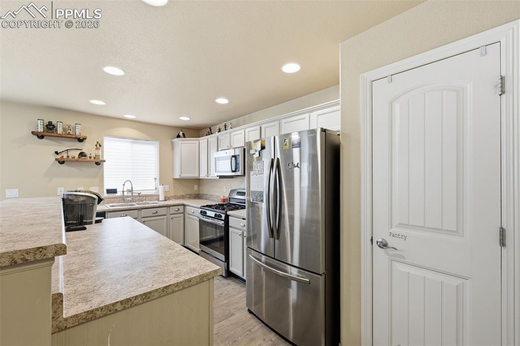 6186 Pilgrimage Road Colorado Springs, CO 80925 - Photo 9 of 20 a kitchen with stainless steel appliances granite countertop a refrigerator and a sink