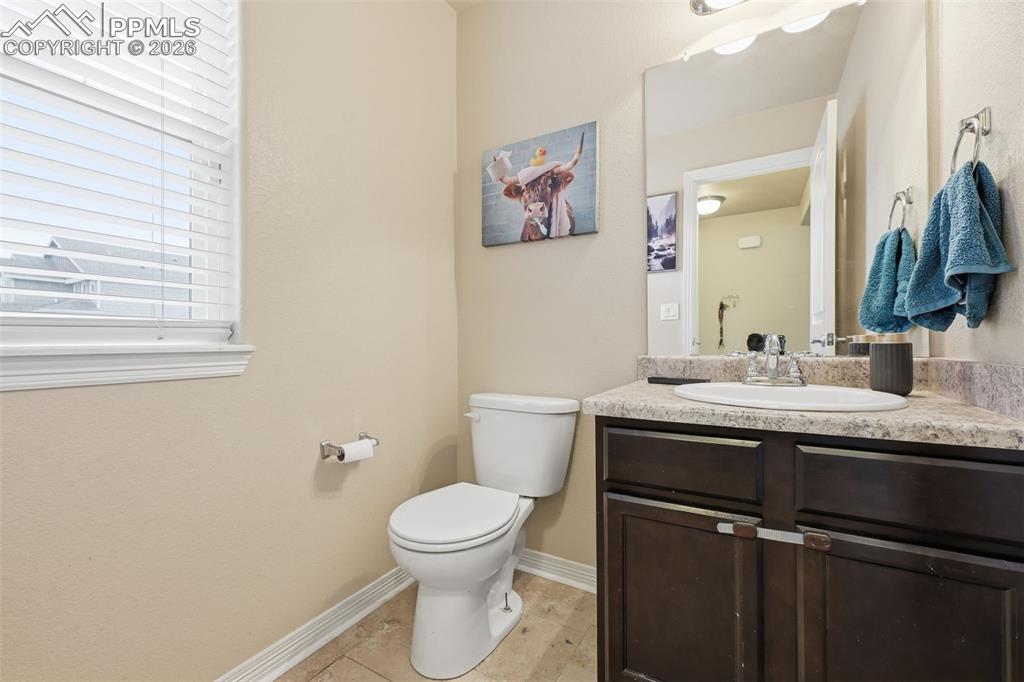6186 Pilgrimage Road Colorado Springs, CO 80925 - Photo 10 of 20 a bathroom with a granite countertop toilet sink and mirror