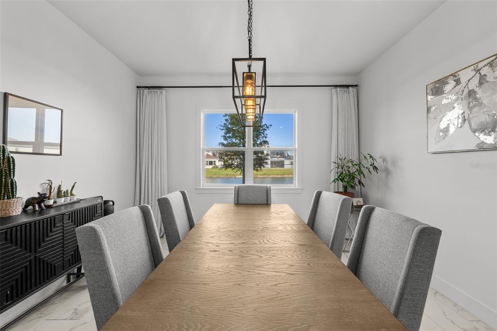9185 Sanders Tree Loop Wesley Chapel, FL 33545 - Photo 13 of 48 a view of a dining room with furniture window and wooden floor