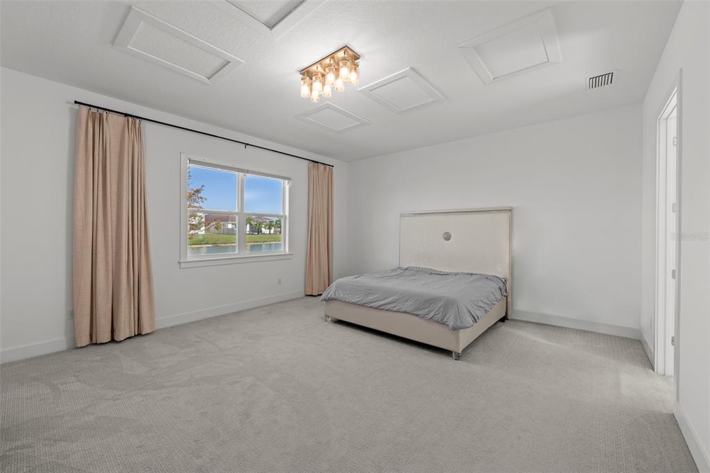 9185 Sanders Tree Loop Wesley Chapel, FL 33545 - Photo 14 of 47 a spacious bedroom with a bed and a window