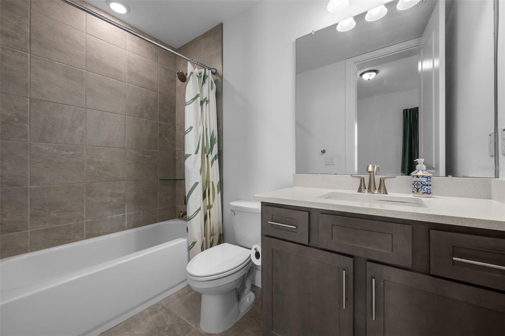 9185 Sanders Tree Loop Wesley Chapel, FL 33545 - Photo 18 of 47 a bathroom with a bathtub shower sink vanity mirror and toilet