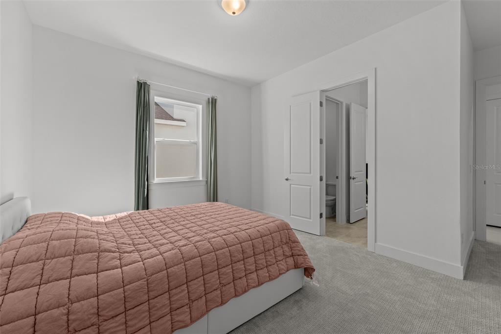 9185 Sanders Tree Loop Wesley Chapel, FL 33545 - Photo 20 of 47 a bedroom with a bed and a window