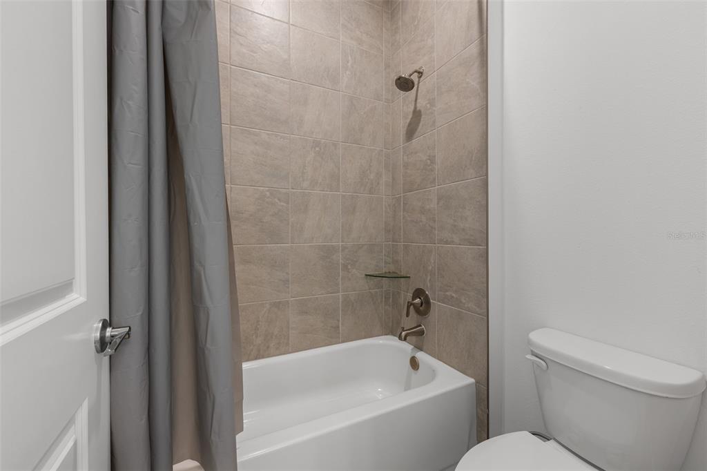 9185 Sanders Tree Loop Wesley Chapel, FL 33545 - Photo 22 of 47 a white bath tub sitting next to a white toilet