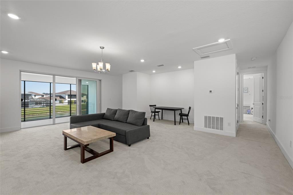 9185 Sanders Tree Loop Wesley Chapel, FL 33545 - Photo 26 of 48 a living room with furniture and a large window