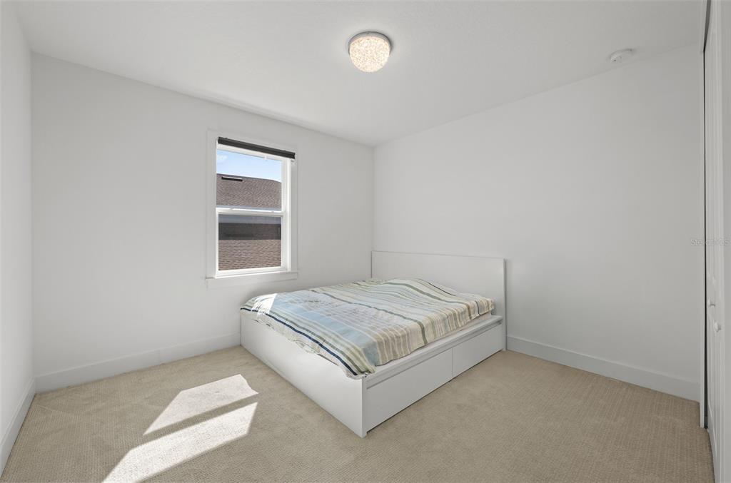 9185 Sanders Tree Loop Wesley Chapel, FL 33545 - Photo 27 of 47 a spacious bedroom with a bed and window