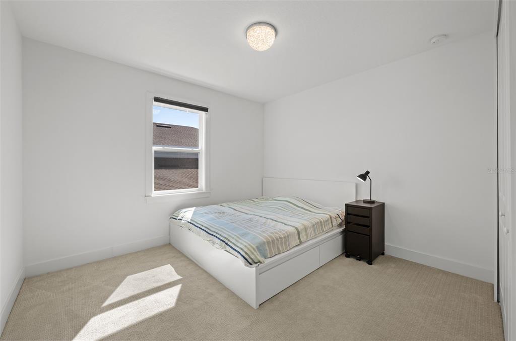 9185 Sanders Tree Loop Wesley Chapel, FL 33545 - Photo 28 of 48 a spacious bedroom with a bed and a window