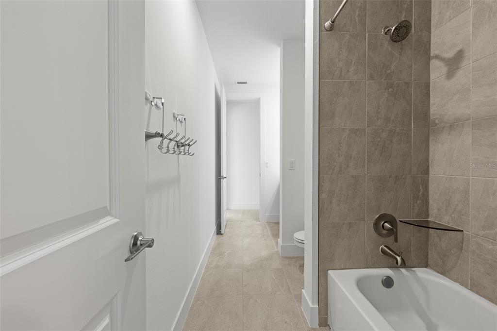 9185 Sanders Tree Loop Wesley Chapel, FL 33545 - Photo 30 of 48 a bathroom with a tub shower and toilet