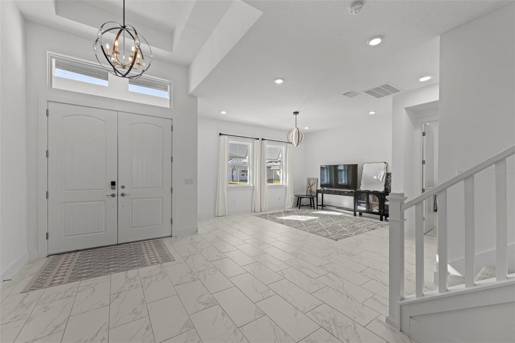 9185 Sanders Tree Loop Wesley Chapel, FL 33545 - Photo 3 of 48 a view of a livingroom with a furniture wooden floor and a chandelier