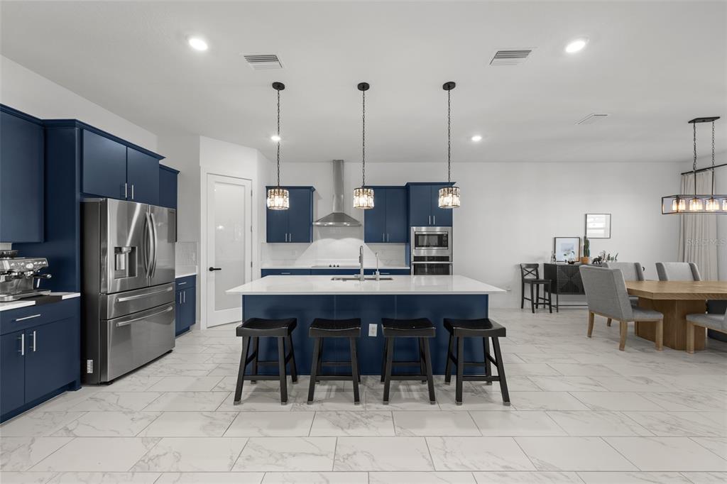 9185 Sanders Tree Loop Wesley Chapel, FL 33545 - Photo 7 of 48 a large kitchen with a table and chairs