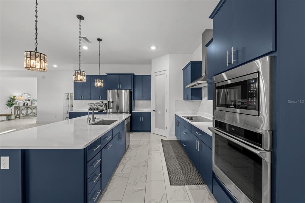 9185 Sanders Tree Loop Wesley Chapel, FL 33545 - Photo 8 of 48 a large kitchen with a stove and a sink