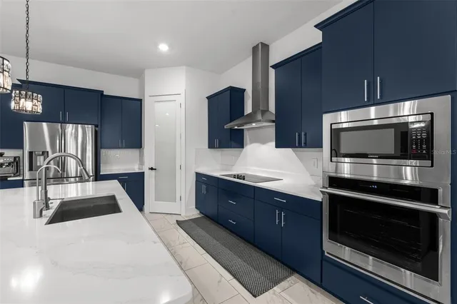 a large kitchen with stainless steel appliances wooden cabinets and a stove top oven