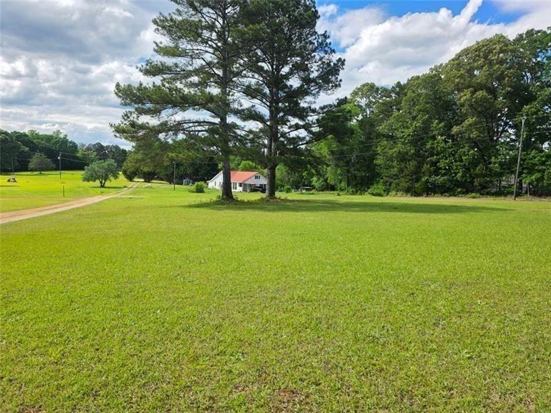 a view of a green field with an trees in the background