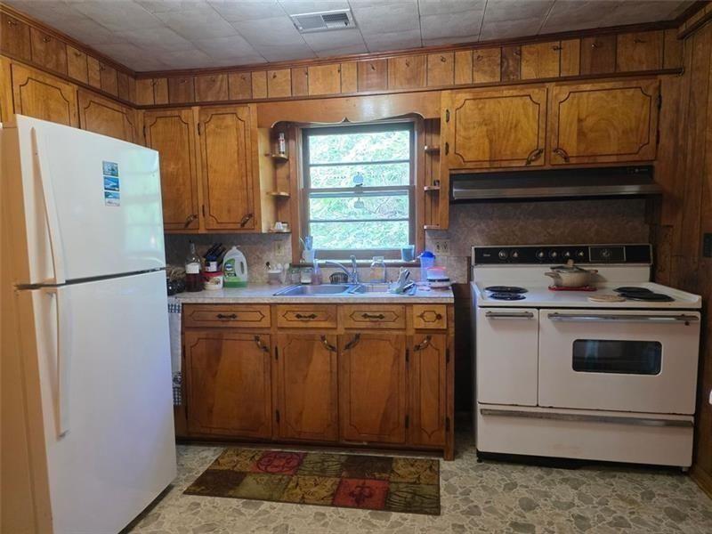 3834 Highway 124 Jefferson, GA 30549 - Photo 10 of 12 a kitchen with granite countertop a refrigerator a stove a sink and dishwasher