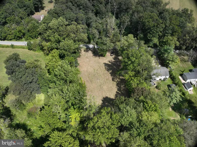 an aerial view of residential house with outdoor space and trees all around
