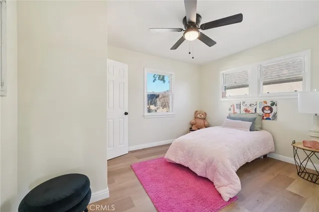 a bedroom with a bed a chandelier and a chair