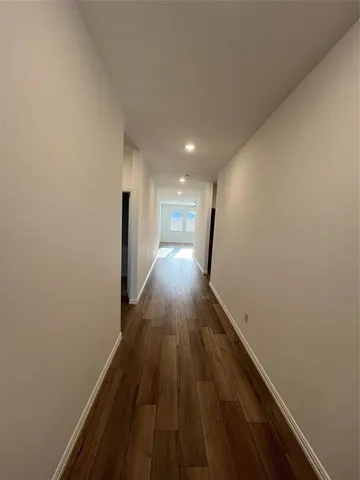 a view of a kitchen with a stove cabinets a ceiling fan and wooden floor