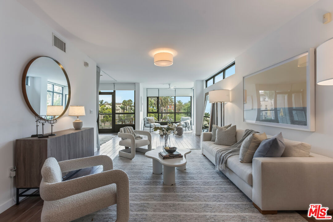 13045 Pacific Promenade, Unit 330 Los Angeles, CA 90094 - Photo 9 of 43 a living room with furniture a rug a lamp and a large window