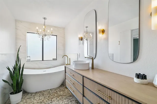 a bathroom with a double vanity sink a mirror and bathtub