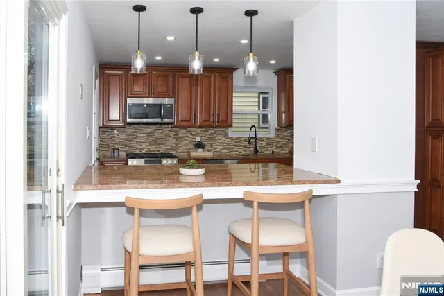 a kitchen with kitchen island granite countertop a table and chairs in it