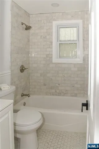 a bathroom with a toilet and a bath tub