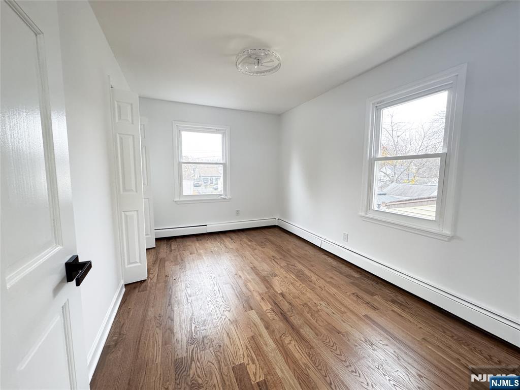 47 Elston Street Bloomfield, NJ 07003 - Photo 24 of 38 an empty room with wooden floor and windows
